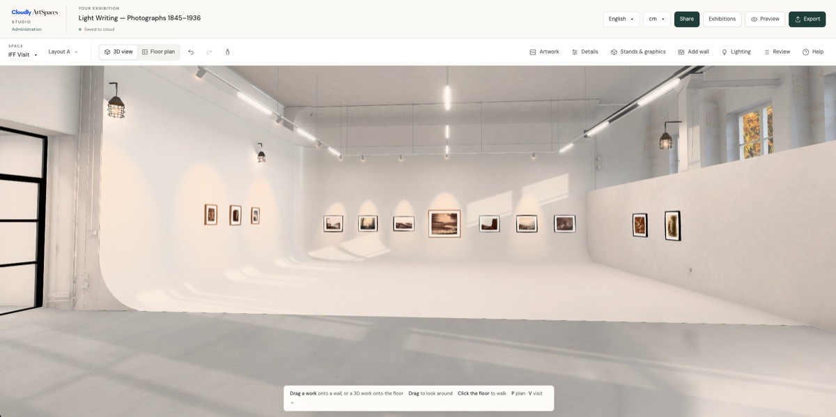 Cloudly ArtSpaces Studio in 3D view: the IFF Visit gallery model with a white cyclorama wall and framed historic photographs from the demonstration exhibition Light Writing, Photographs 1845–1936, hung along the walls